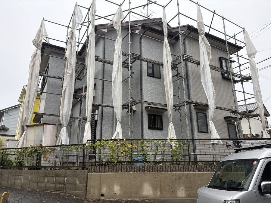 足場とシートを設置した住宅